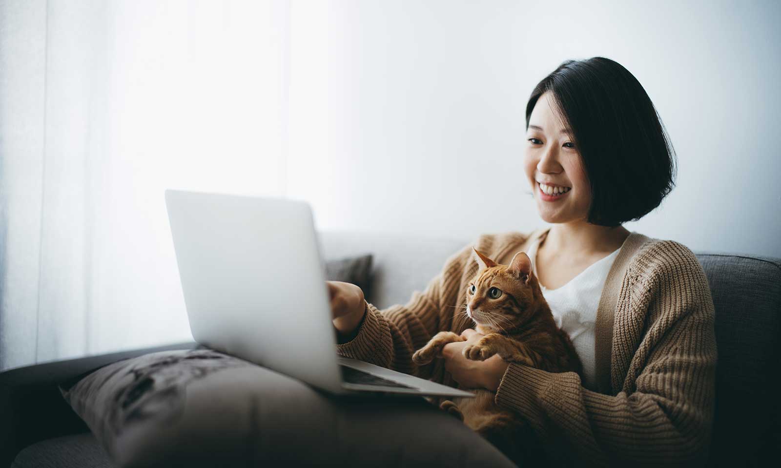 A woman and cat looking at their computer